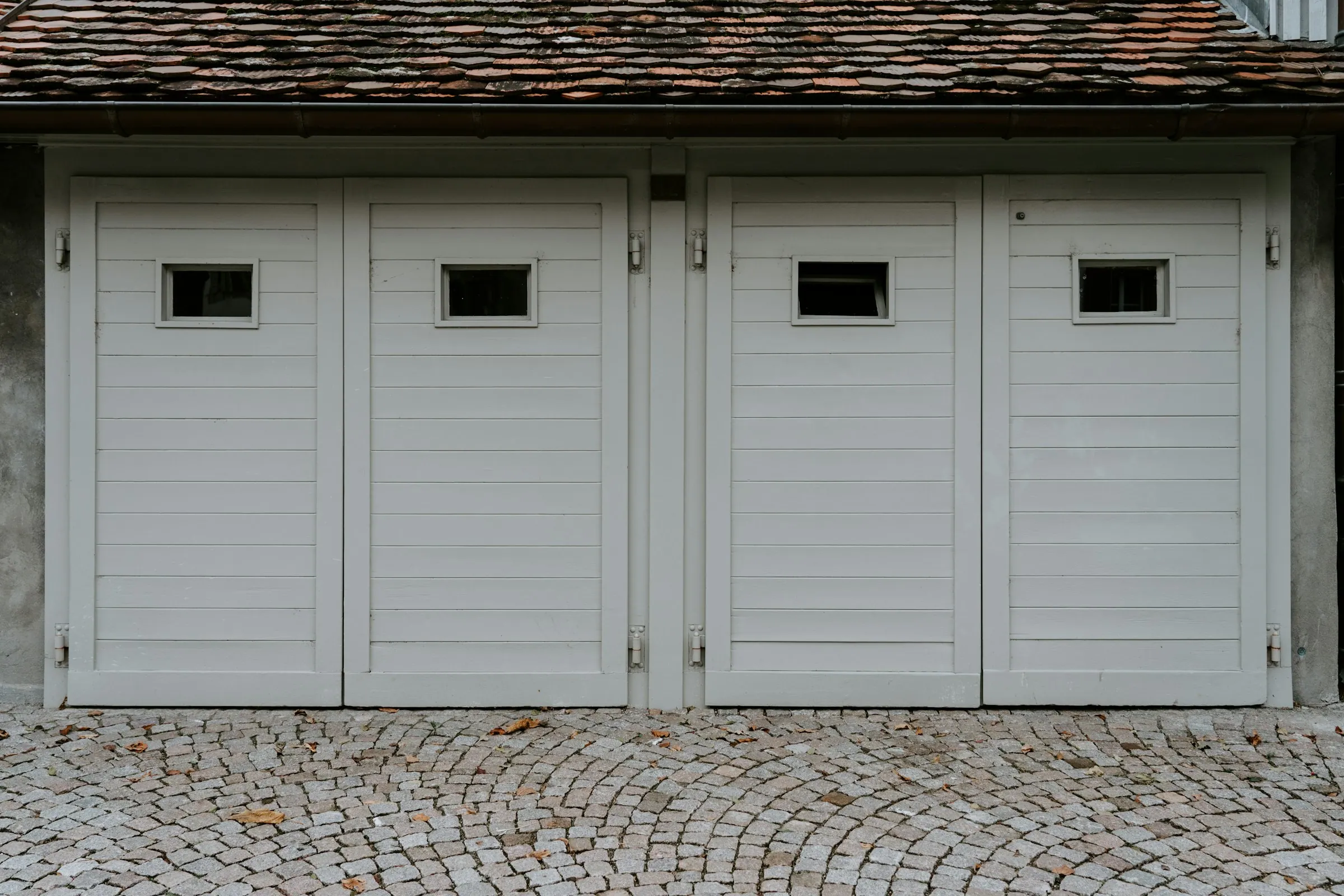 Closed white carriage-style wooden garage door