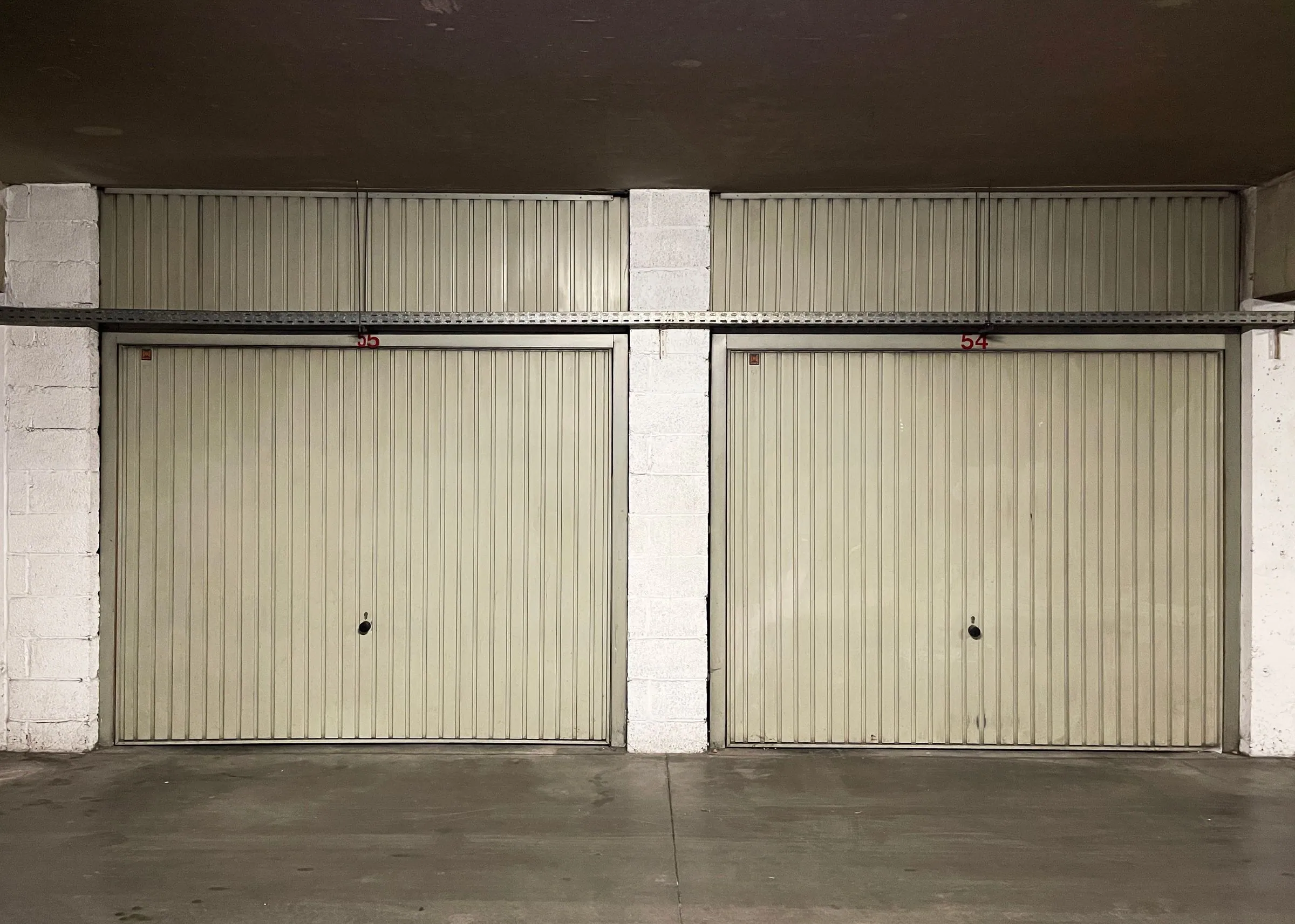 Interior view of closed garage doors with overhead track and rails